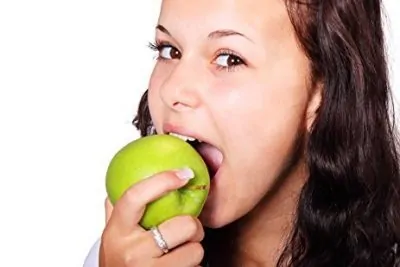 chica comiendo una manzana verde