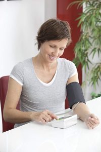 mujer midiendo presion arterial a traves del brazo