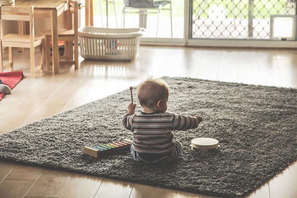 bebé sentado en una alfombra