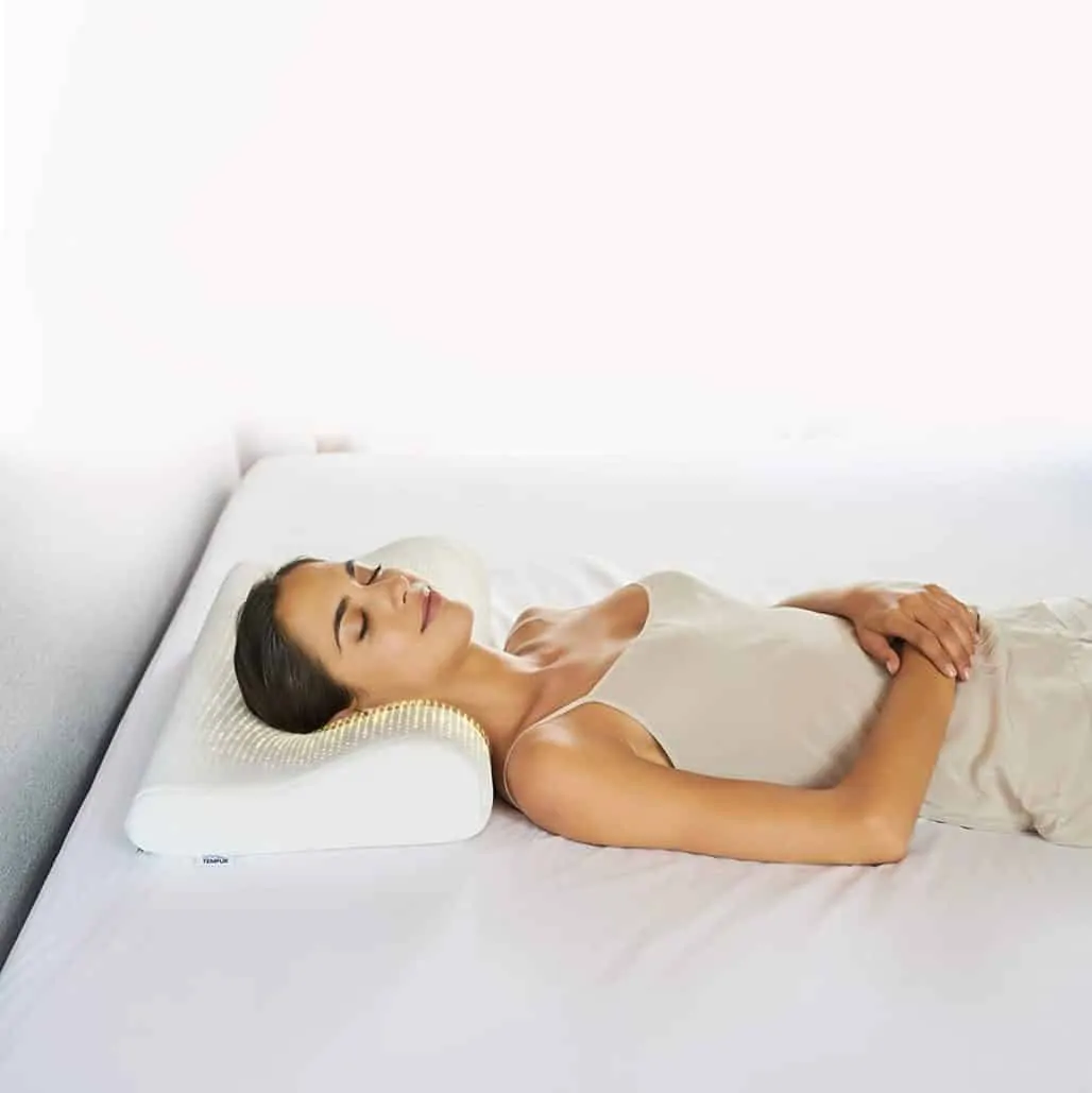 Mujer durmiendo con una almohada cervical