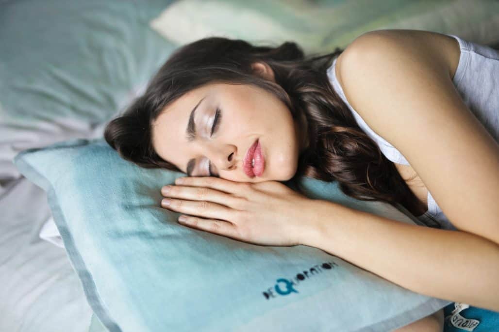 mujer durmiendo de lado con una almohada