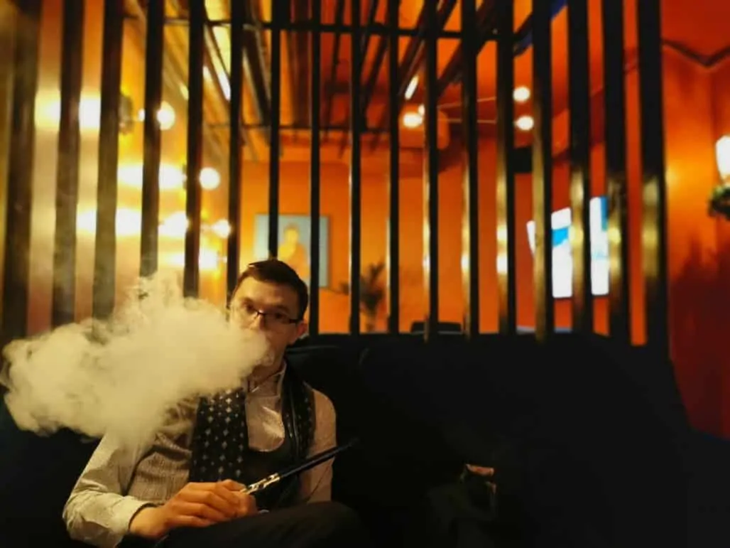 Hombre fumando en la sala.