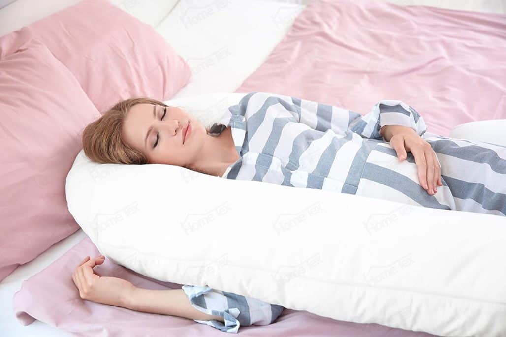 Mujer embarazada acostada usando una almohada