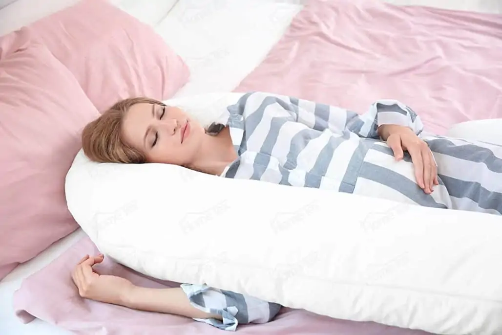 Mujer embarazada acostada usando una almohada
