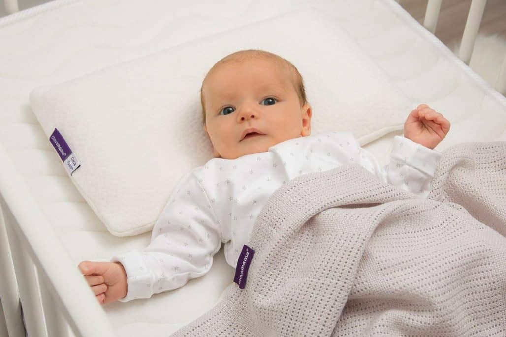 Bebé en la cuna acostado sobre una almohada