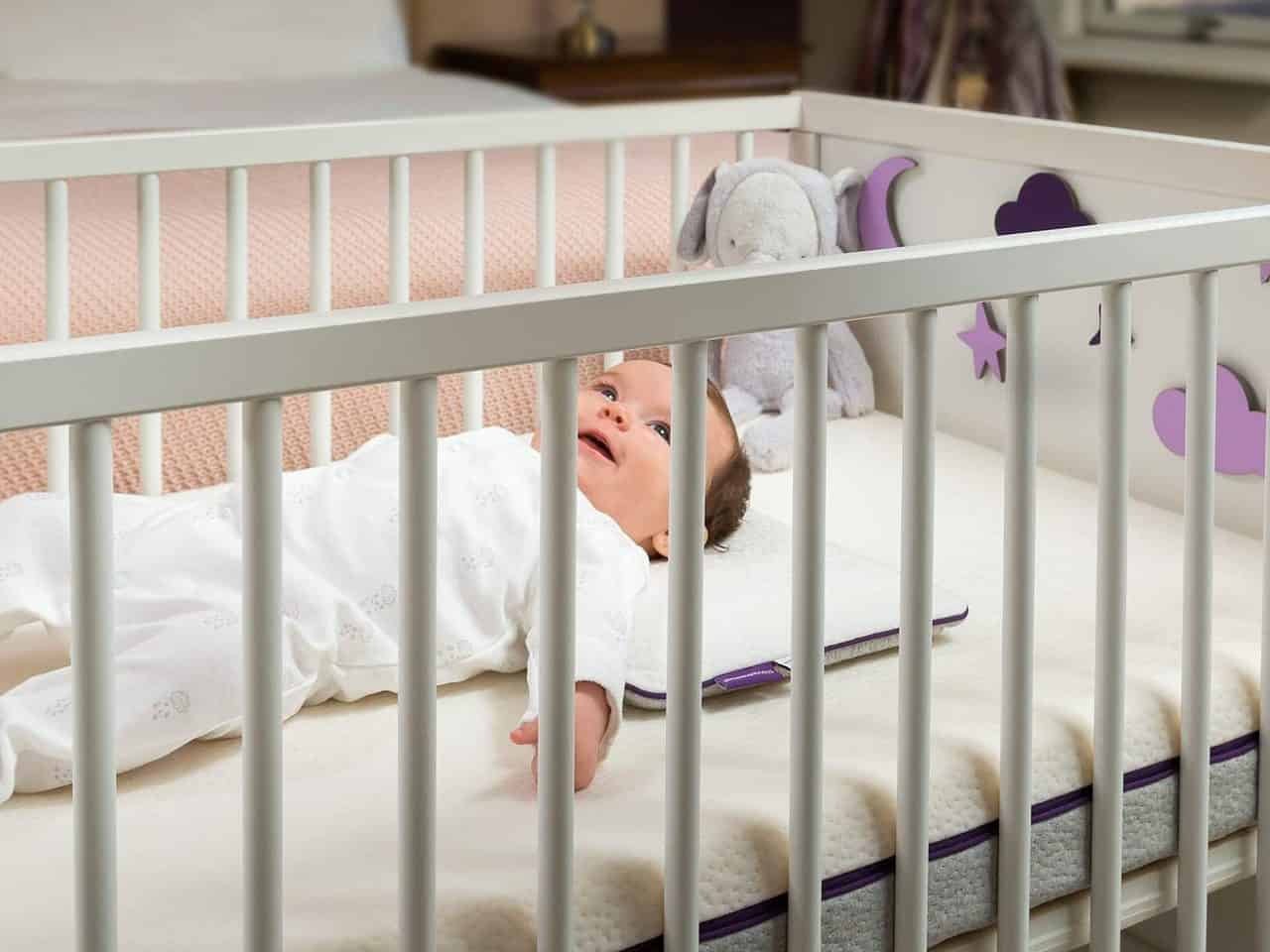Bebé en la cuna acostado sobre una almohada
