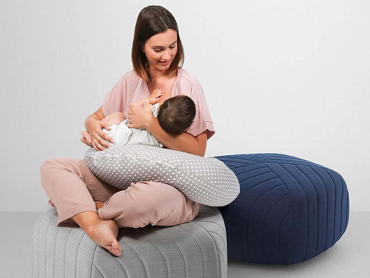 Mujer amamantando a un bebé usando una almohada en forma de C