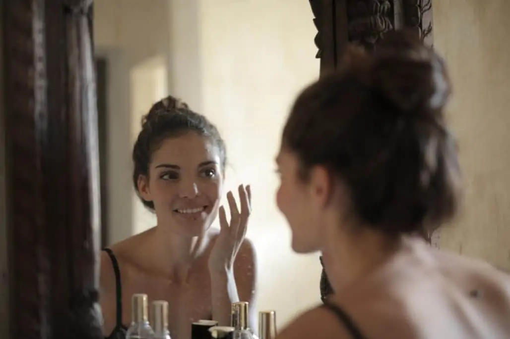 mujer sonriendo frente al espejo